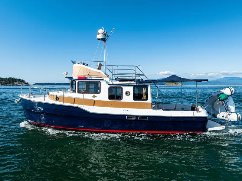 Slide: The Image of 2014 Ranger Tugs R-31CB cruising on open water under clear blue skies. - 36