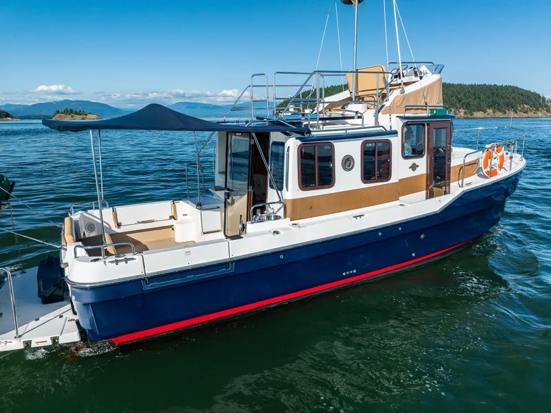 Slide: The Image of 2014 Ranger Tugs R-31CB boat on calm water with scenic background. - 7