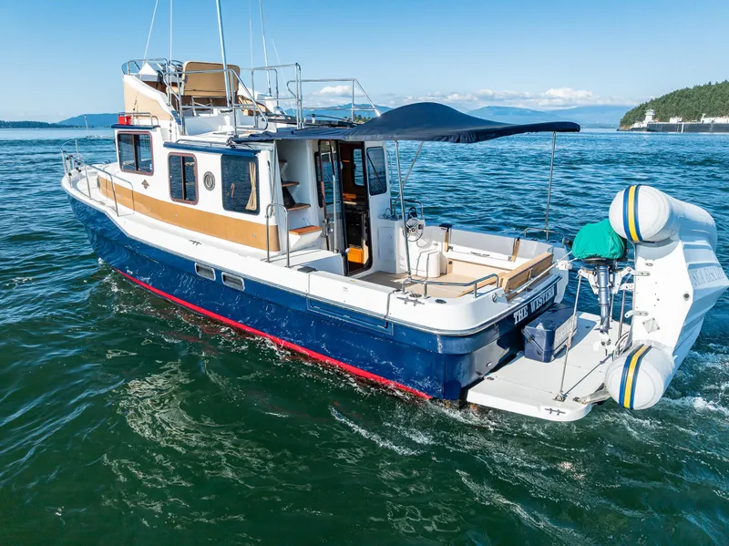 Slide: The Image of 2014 Ranger Tugs R-31CB cruising on open water, featuring a spacious deck and modern design. - 9