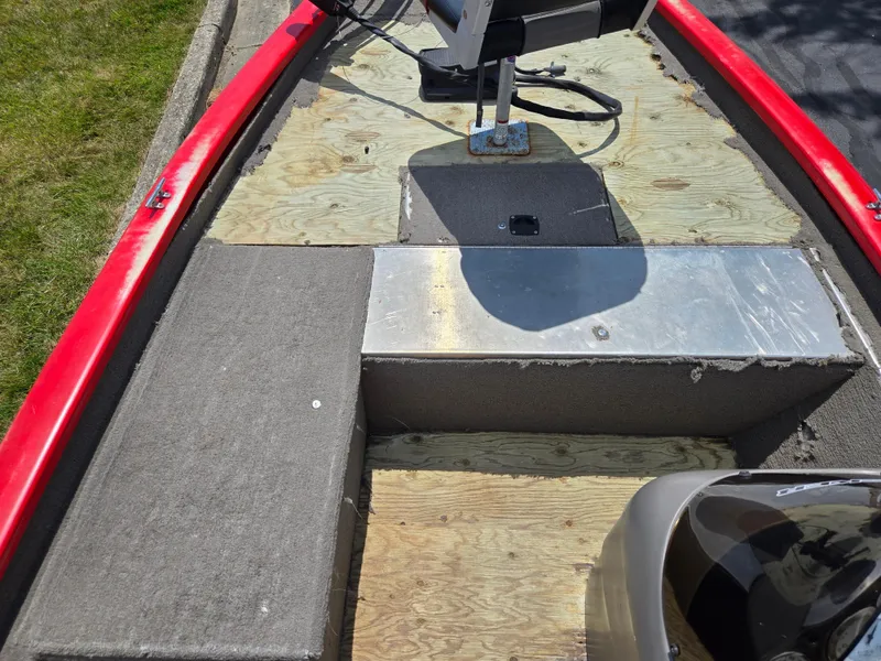Slide: The Image of 2004 Tracker Pro Team 175 boat interior with red trim and exposed plywood flooring. - 13