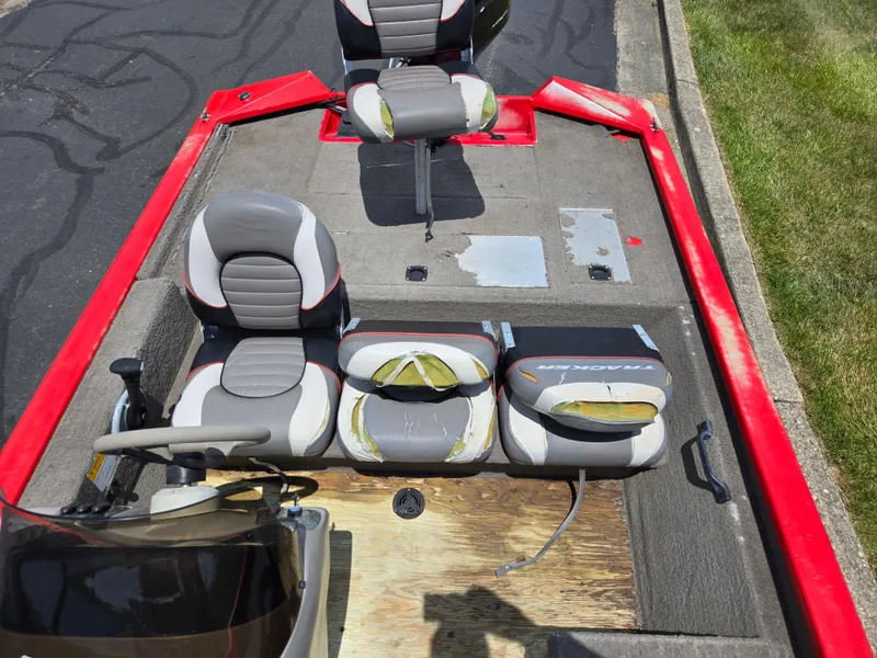 Slide: The Image of 2004 Tracker Pro Team 175 boat with worn seats and red trim, parked on pavement. - 19
