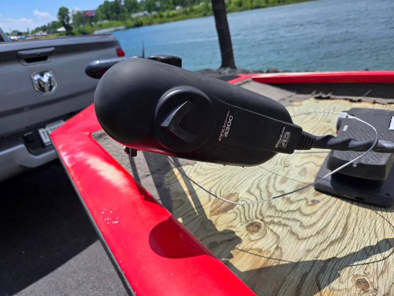 Slide: The Image of 2004 Tracker Pro Team 175 boat with trolling motor near a lake and parked truck. - 9