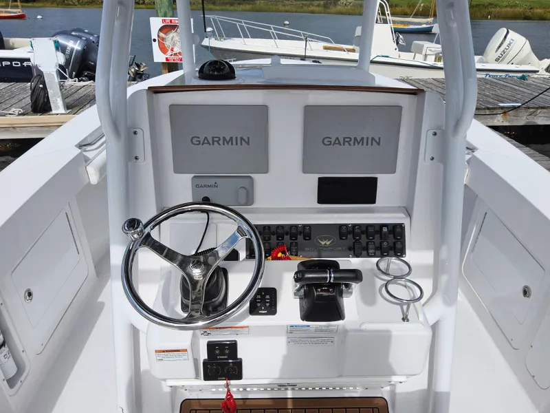 Slide: The Image of Control panel of 2022 Southport 27 FE boat with Garmin displays and steering wheel. - 12