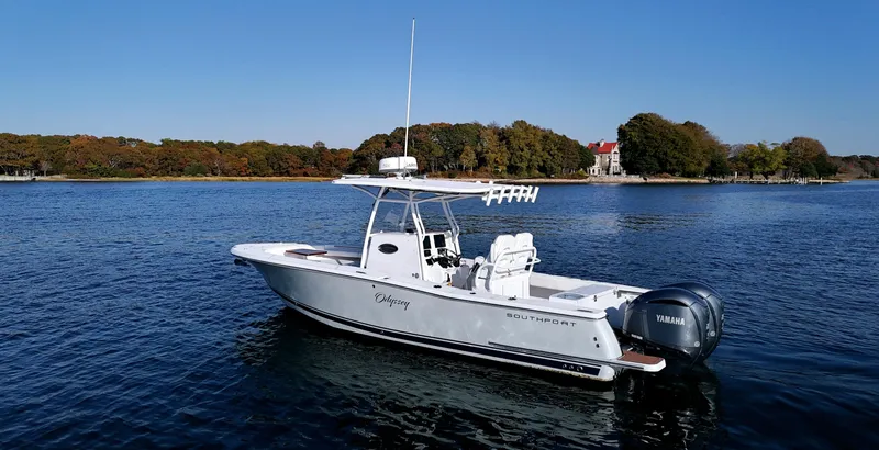 Slide: The Image of 2022 Southport 27 FE boat on calm water with scenic shoreline background. - 2