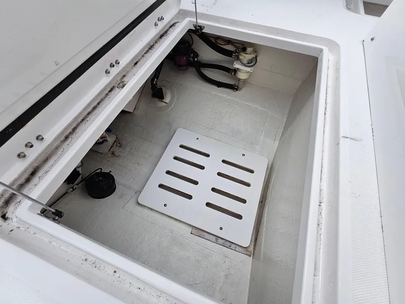 Slide: The Image of 2022 Southport 27 FE boat storage compartment with open hatch and visible components. - 7