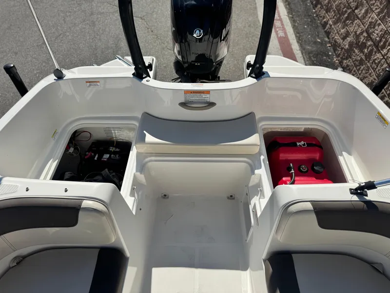 Slide: The Image of 2019 Bayliner Element E16 boat interior with storage compartments and engine view. - 11