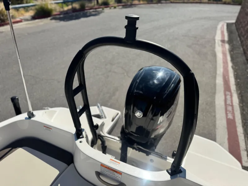 Slide: The Image of 2019 Bayliner Element E16 boat with Mercury outboard motor, parked on pavement. - 13
