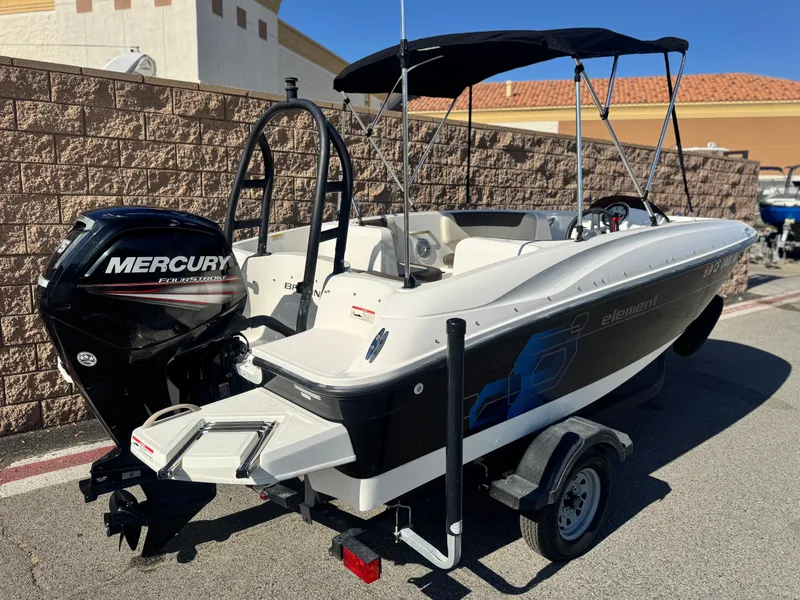 Slide: The Image of 2019 Bayliner Element E16 boat with Mercury engine on trailer, parked outdoors. - 5