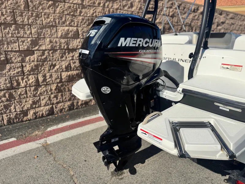 Slide: The Image of 2019 Bayliner Element E16 with Mercury 75HP outboard motor, parked near a brick wall. - 6