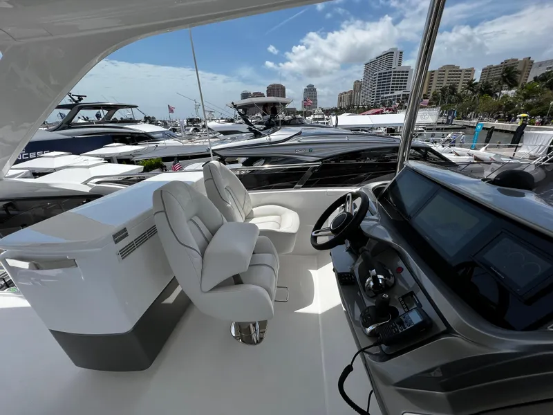 Slide: The Image of Luxury yacht Princess F55 cockpit with modern controls, docked at marina, 2022 model. - 15