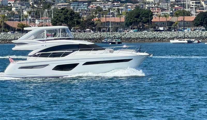 Slide: The Image of Luxury 2022 Princess F55 yacht cruising on a sunny day near a coastal town. - 2