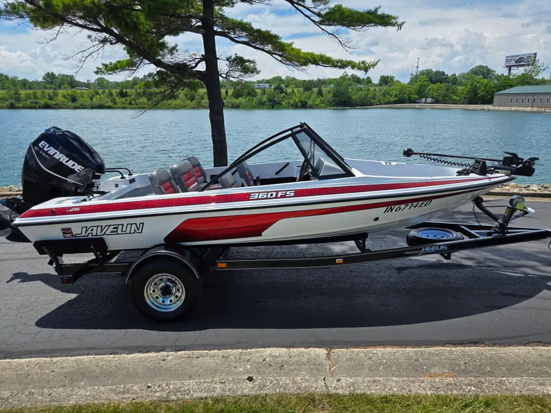 Slide: The Image of 1996 Javelin 360 FS boat on trailer by a lake, featuring Evinrude motor. - 10