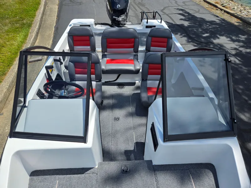 Slide: The Image of 1996 Javelin 360 FS boat interior with red and gray seating, steering wheel, and windshield. - 19