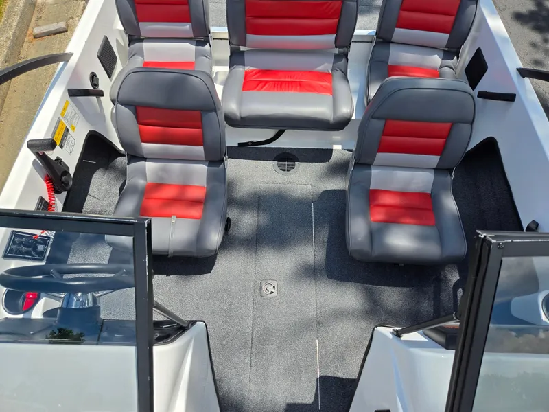 Slide: The Image of 1996 Javelin 360 FS boat interior with red and gray seating, steering wheel, and open deck. - 20