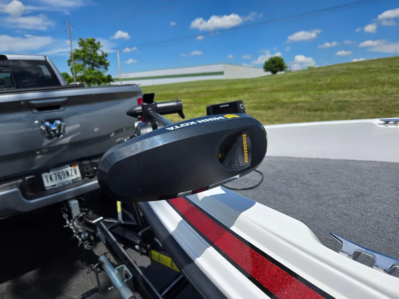Slide: The Image of Boat with Minn Kota PowerDrive motor on trailer, parked near a truck under a clear blue sky. - 6