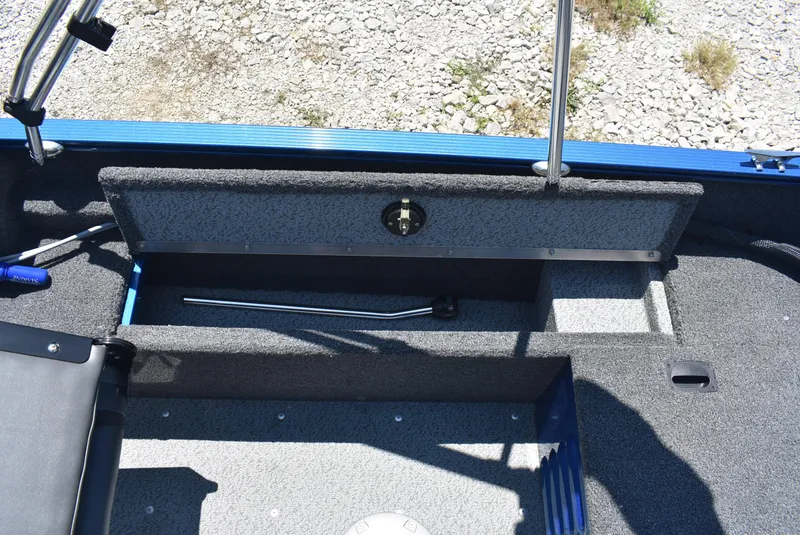 Slide: The Image of 2022 Lund 1650 Angler Sport boat interior with storage compartment and fishing rod holder. - 12