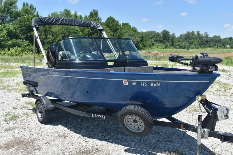Slide: The Image of 2022 Lund 1650 Angler Sport boat on trailer, parked outdoors on gravel. - 3