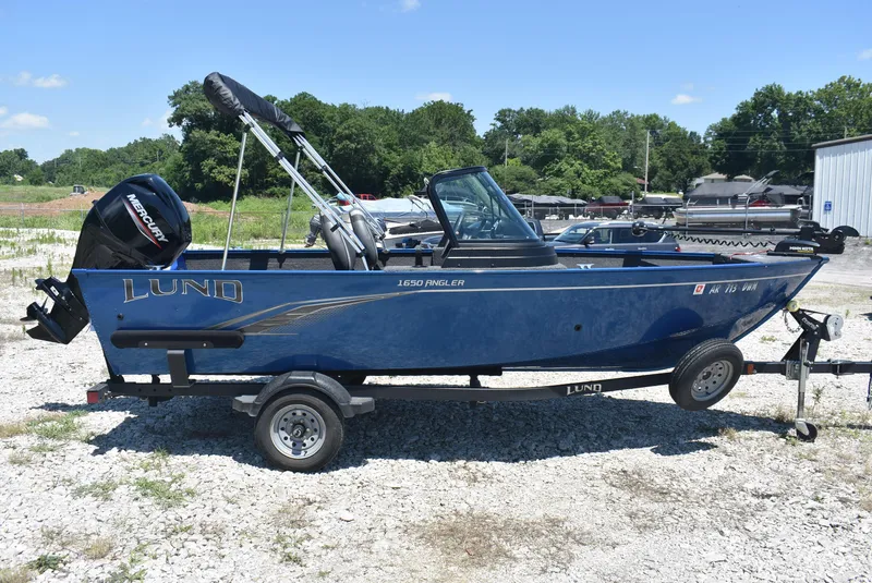 Slide: The Image of 2022 Lund 1650 Angler Sport boat on trailer, blue exterior, parked outdoors. - 4