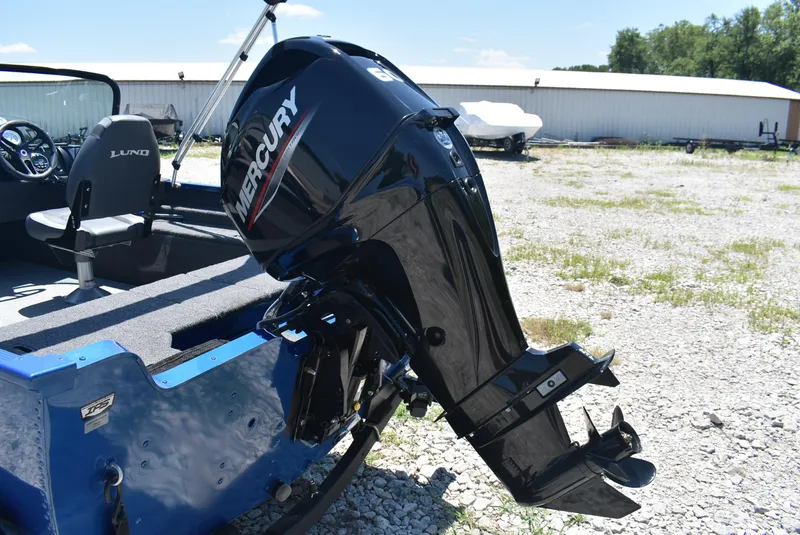 Slide: The Image of 2022 Lund 1650 Angler Sport boat with Mercury outboard motor, parked on gravel. - 5