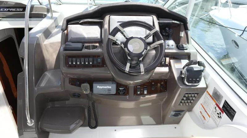 Slide: The Image of 2012 Cruisers Yachts 350 Express helm with steering wheel and control panel. - 10