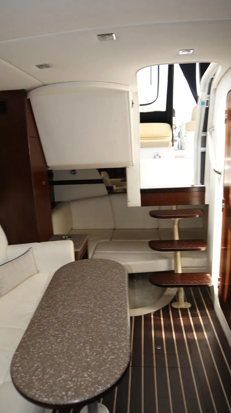 Slide: The Image of Interior of 2012 Cruisers Yachts 350 Express, featuring elegant seating and wooden accents. - 19