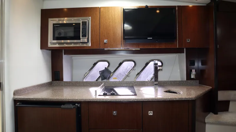 Slide: The Image of 2012 Cruisers Yachts 350 Express kitchen with microwave, TV, and modern fixtures. - 25