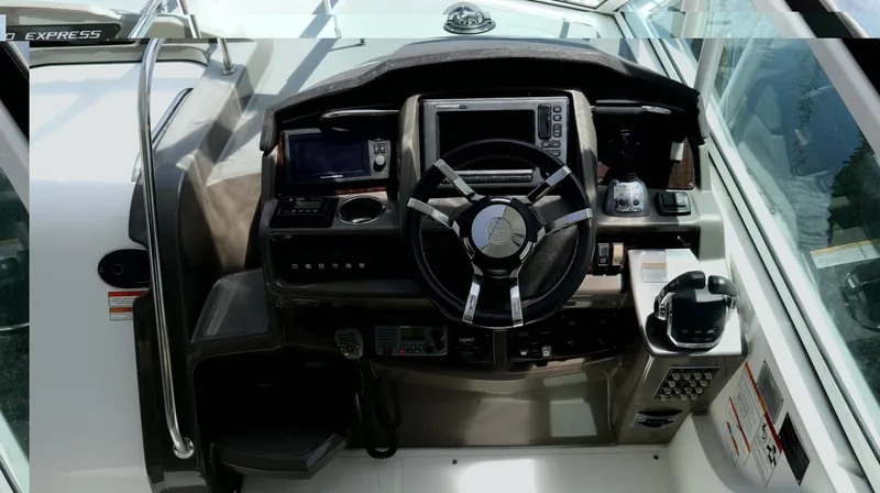 Slide: The Image of 2012 Cruisers Yachts 350 Express helm with steering wheel and navigation controls. - 6