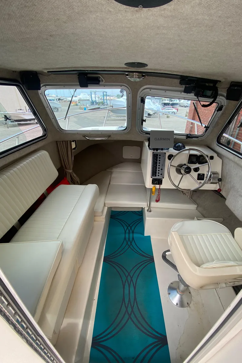 Slide: The Image of Interior of a 2009 Parker 2120 Sport Cabin boat with seating and steering console. - 10