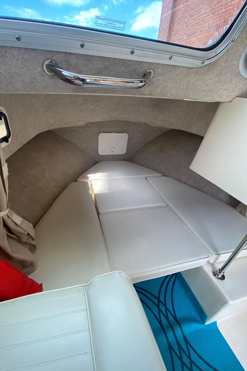 Slide: The Image of 2009 Parker 2120 Sport Cabin interior with cushioned seating and blue mat. - 13