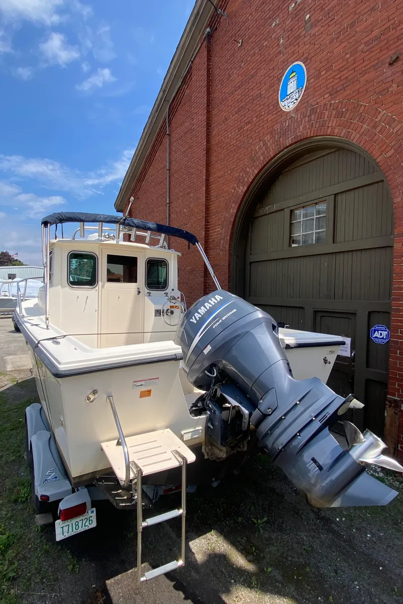 Slide: The Image of 2009 Parker 2120 Sport Cabin boat with Yamaha engine near brick building. - 2