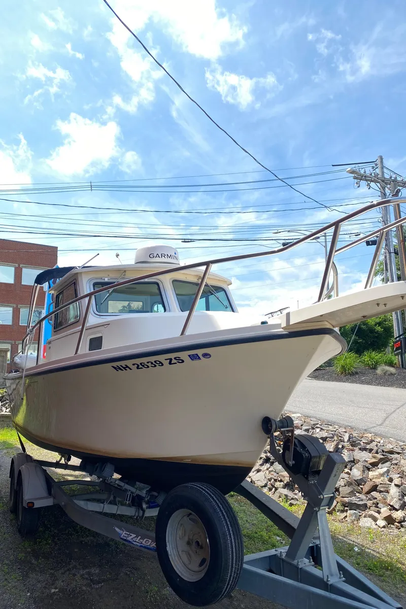 Slide: The Image of 2009 Parker 2120 Sport Cabin boat on trailer under blue sky. - 4