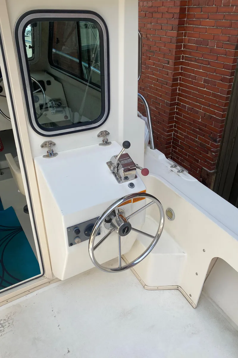 Slide: The Image of 2009 Parker 2120 Sport Cabin boat helm with steering wheel and control panel. - 7