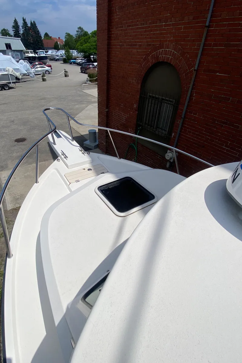 Slide: The Image of 2009 Parker 2120 Sport Cabin boat docked near a brick building. - 8