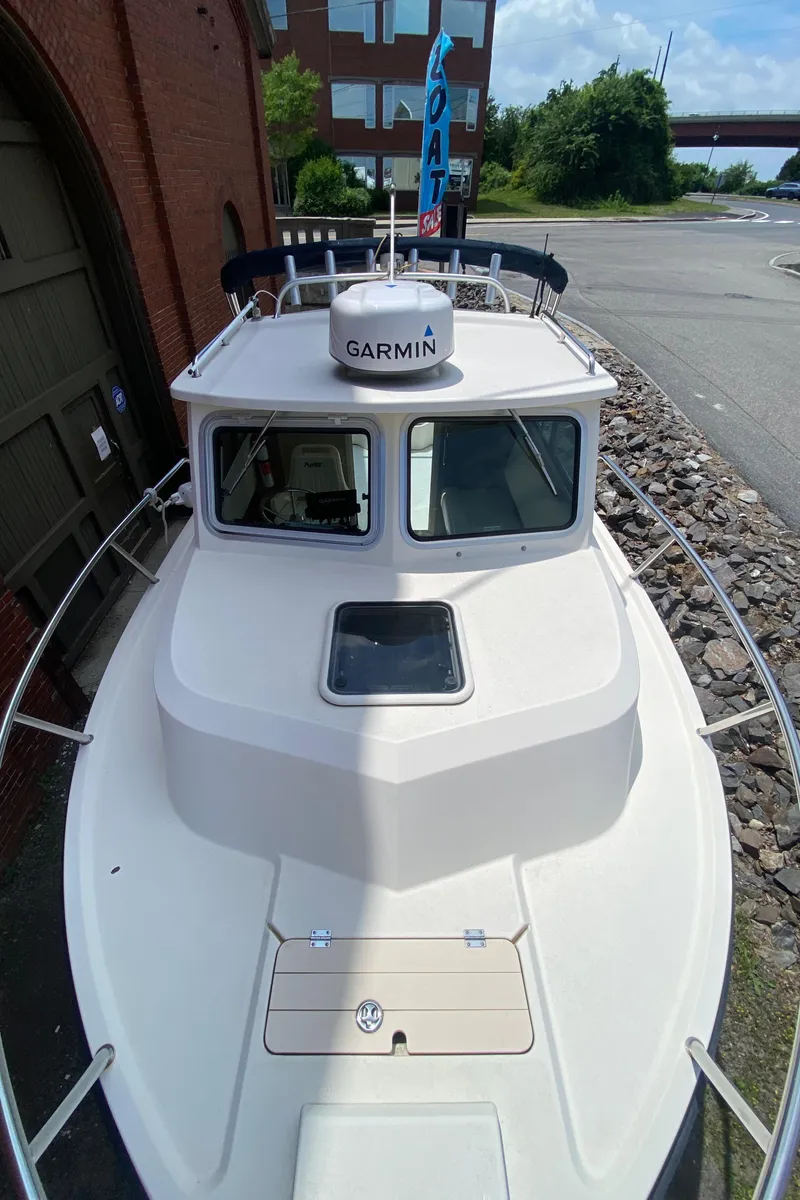 Slide: The Image of 2009 Parker 2120 Sport Cabin boat with Garmin equipment, docked near a brick building. - 9