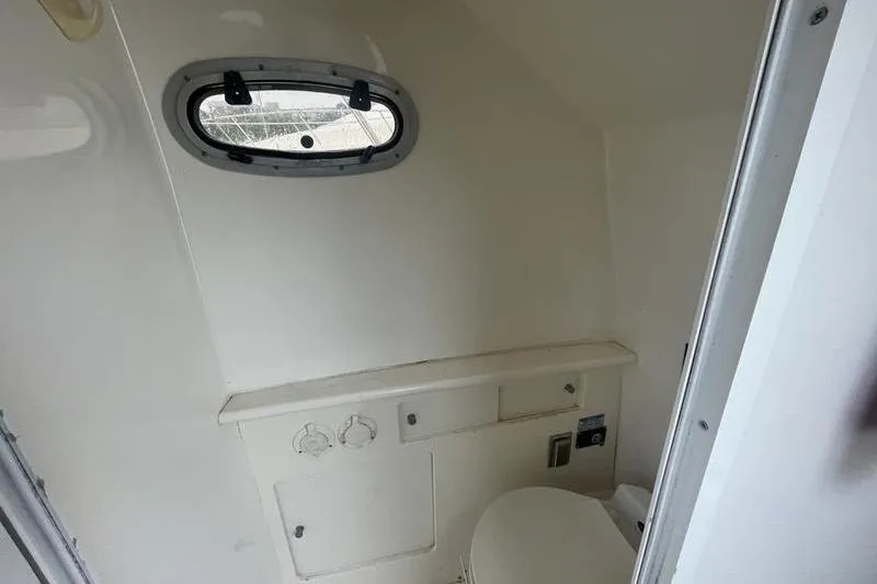 Slide: The Image of Interior of 2000 Boston Whaler 28 Outrage boat bathroom with porthole window. - 10