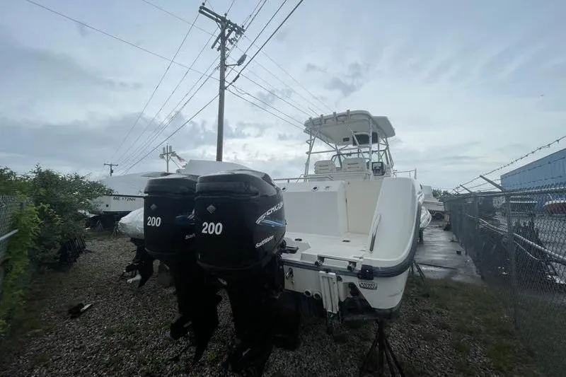 Slide: The Image of 2000 Boston Whaler 28 Outrage boat with dual 200 horsepower engines, parked outdoors. - 5