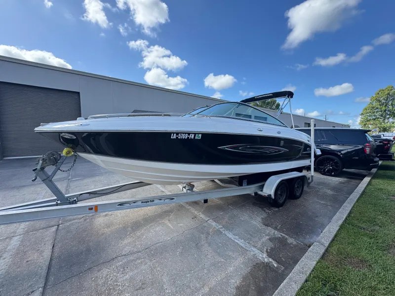 The Image of 2006 Chaparral 236 SSi boat on trailer, parked outdoors under a blue sky. - 0