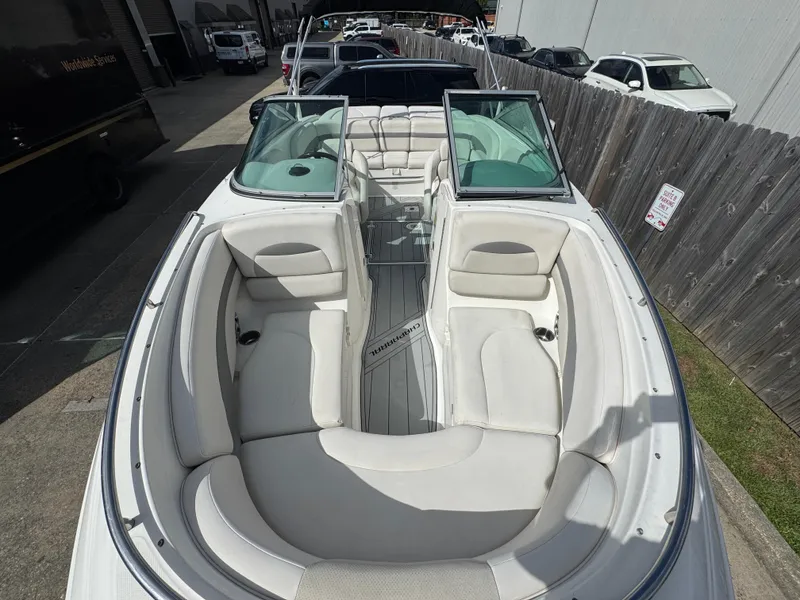 Slide: The Image of 2006 Chaparral 236 SSi boat with white interior seating, parked outdoors. - 14