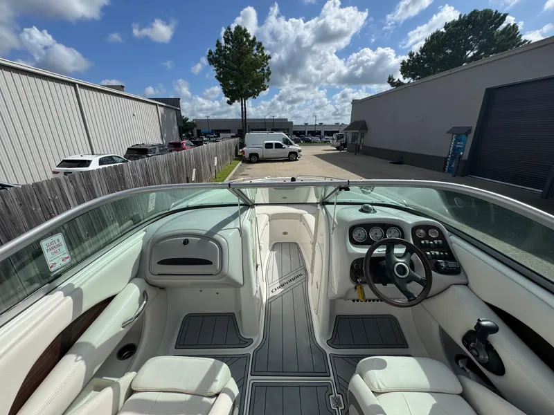 Slide: The Image of 2006 Chaparral 236 SSi boat interior with steering wheel and dashboard, parked outdoors. - 15
