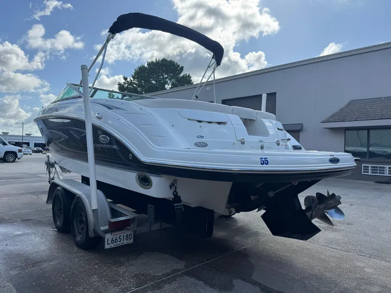 Slide: The Image of 2006 Chaparral 236 SSi boat on trailer, parked outdoors under a partly cloudy sky. - 2