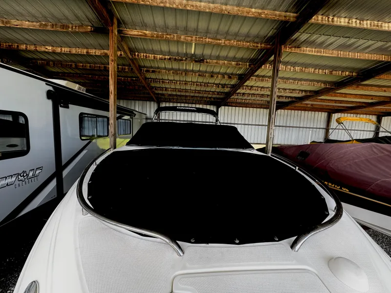 Slide: The Image of 2006 Chaparral 236 SSi boat under a metal shelter, parked beside a camper. - 23
