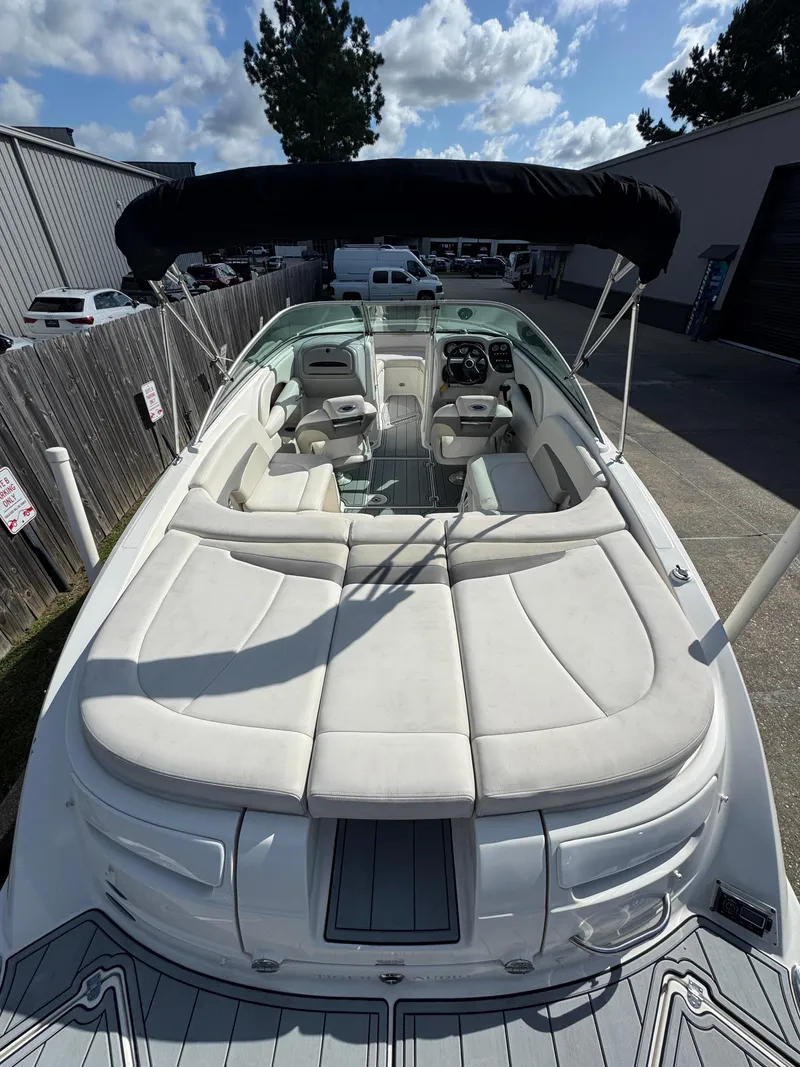 Slide: The Image of 2006 Chaparral 236 SSi boat with spacious seating and canopy, parked outdoors. - 6
