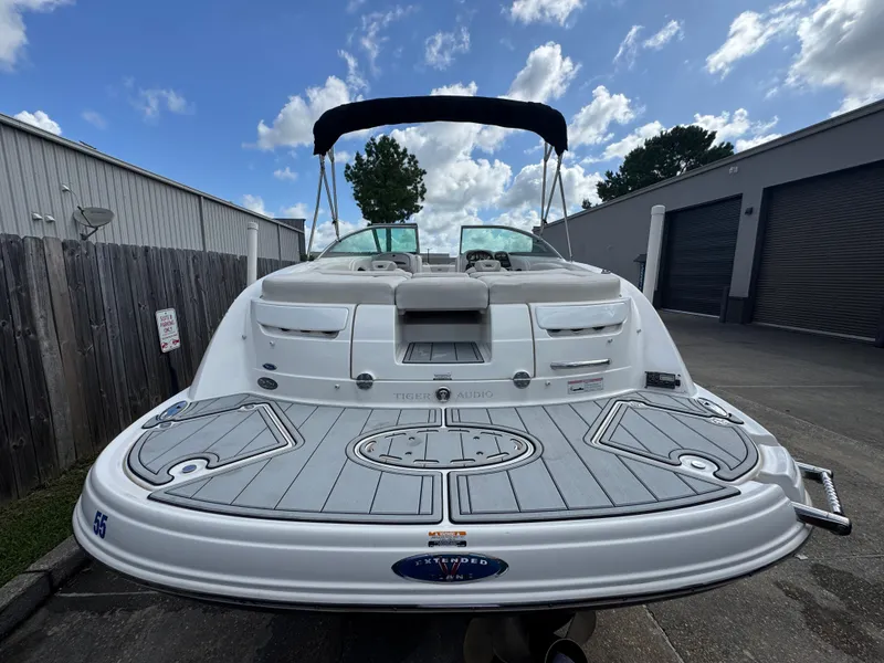 Slide: The Image of 2006 Chaparral 236 SSi boat with swim platform, docked outdoors under a cloudy sky. - 7