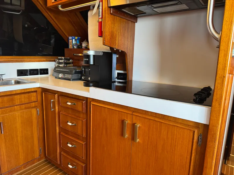 Slide: The Image of 1981 Bertram 58 Flybridge Motor Yacht kitchen with wooden cabinets and modern appliances. - 10