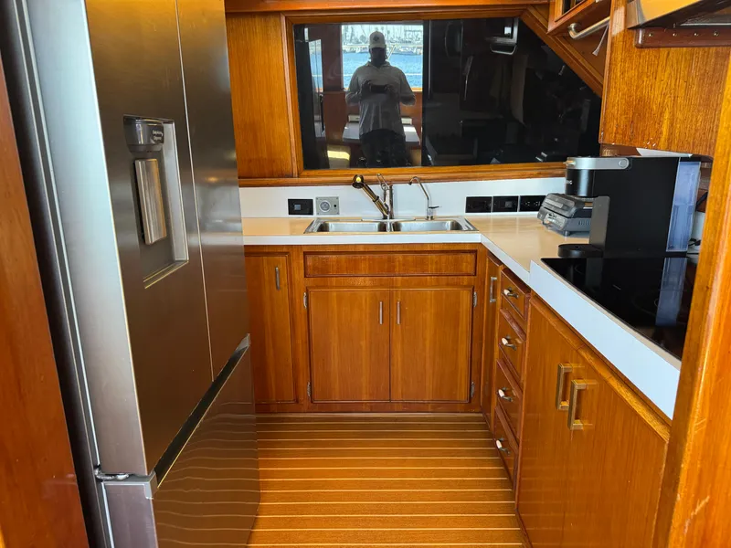 Slide: The Image of 1981 Bertram 58 Flybridge Motor Yacht kitchen with wood cabinetry and modern appliances. - 12