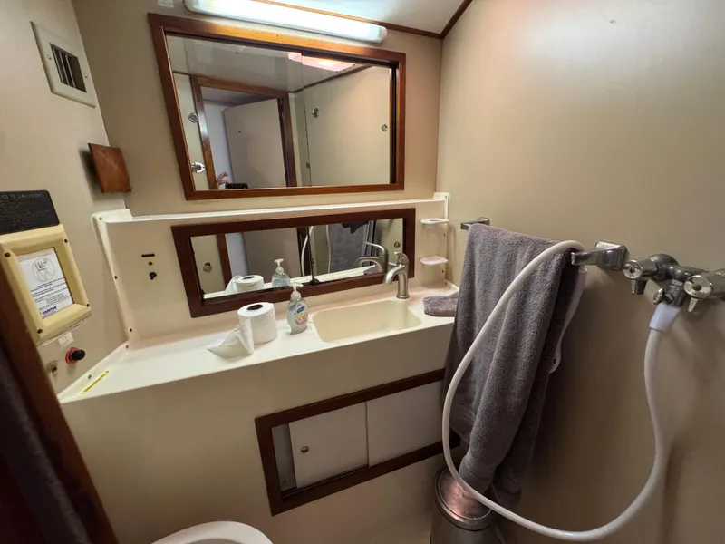 Slide: The Image of 1981 Bertram 58 Flybridge Motor Yacht bathroom with sink, mirror, and towel. - 19