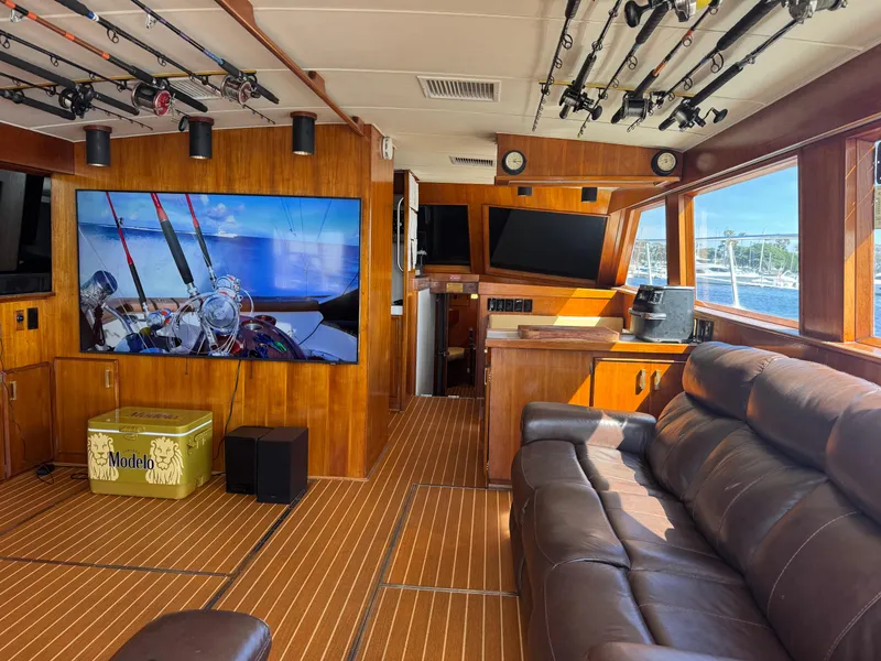 Slide: The Image of Luxurious interior of 1981 Bertram 58 Flybridge Motor Yacht with fishing rods and leather seating. - 2