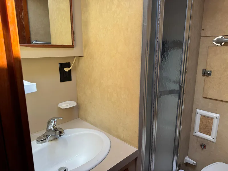 Slide: The Image of 1981 Bertram 58 Flybridge Motor Yacht bathroom with sink, mirror, and shower. - 22