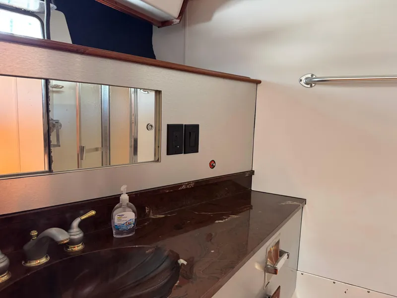 Slide: The Image of 1981 Bertram 58 Flybridge Motor Yacht bathroom with marble countertop and mirrored cabinet. - 25