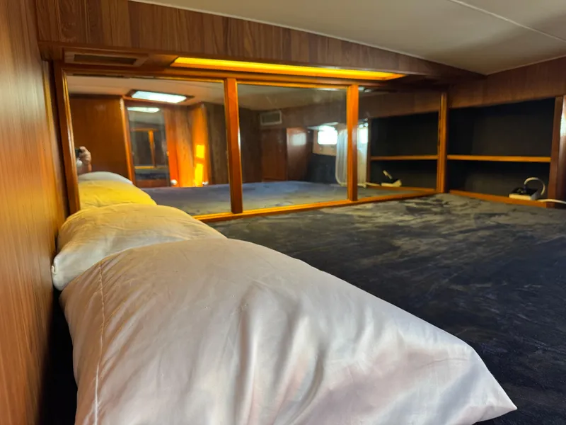 Slide: The Image of Cozy bedroom interior of 1981 Bertram 58 Flybridge Motor Yacht with wood paneling and mirrors. - 27